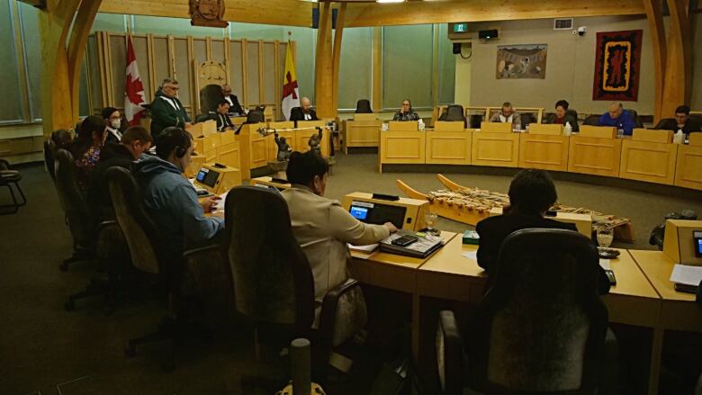 A politician stands in a legislative assembly building.