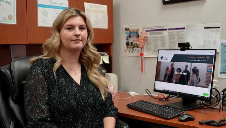 Woman sitting at a desk in an office.