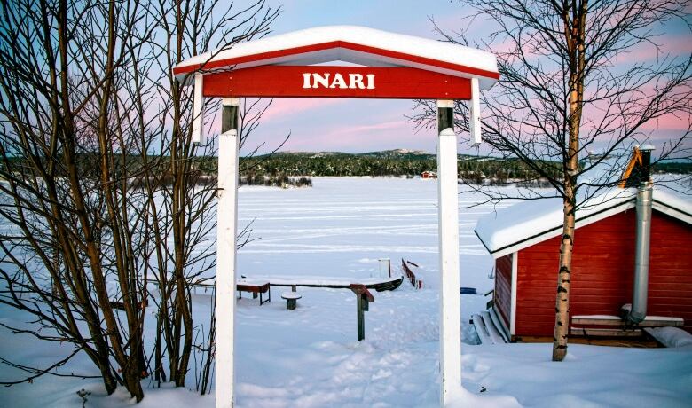 A sign that says Inari in front of a snowy frozen landscape.