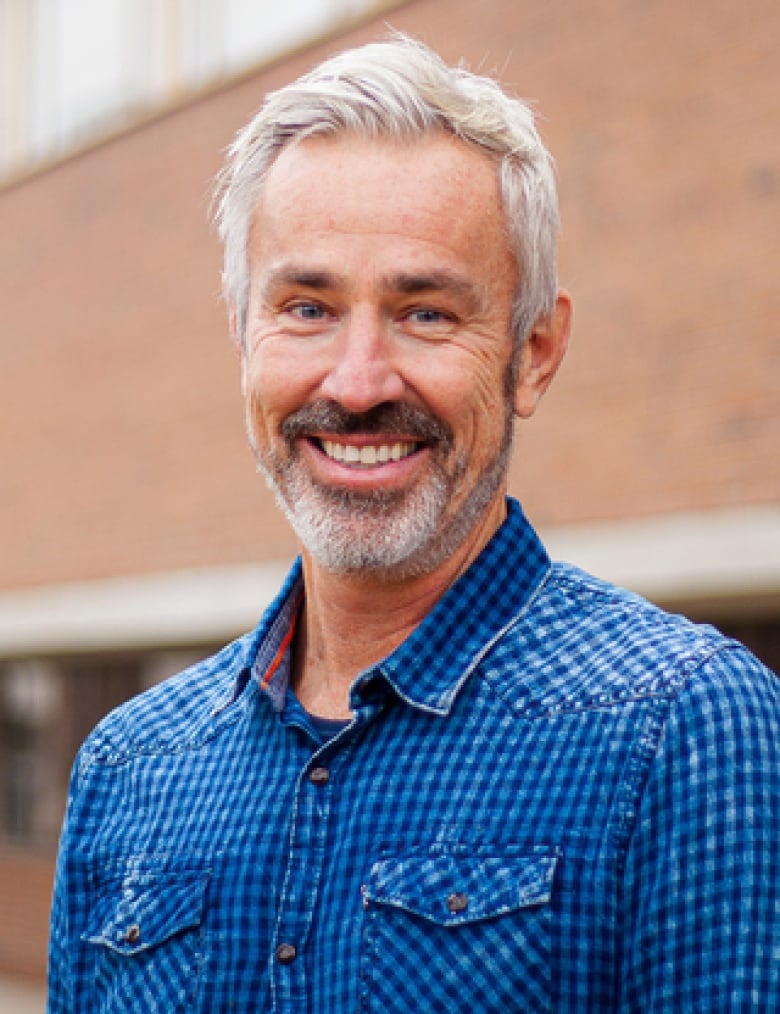 A bearded man smiles.