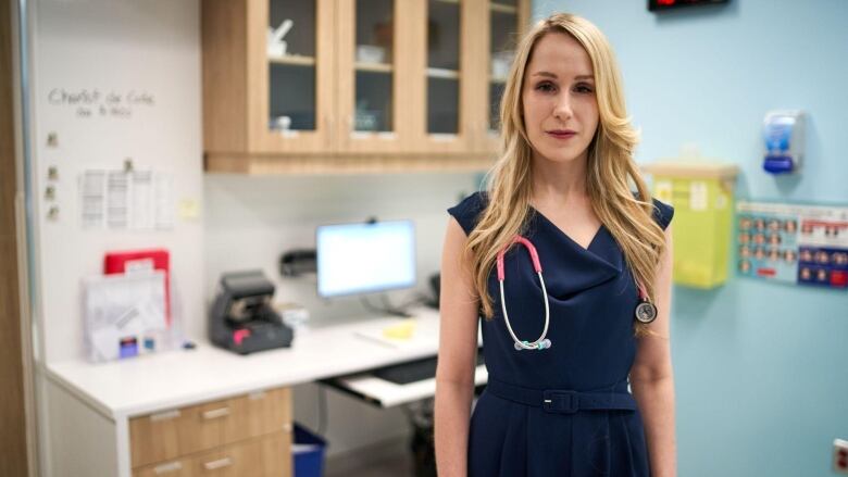 A woman stands in an office.