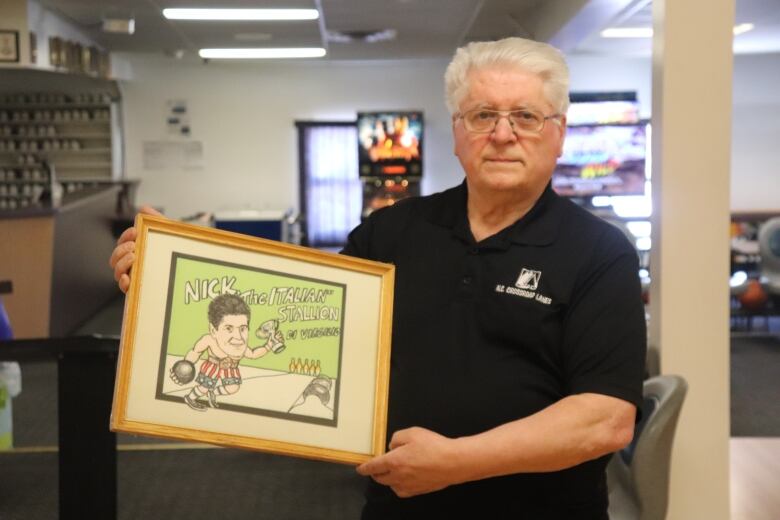 A man in a black bowling shirt holds a picture that reads 'Nick, The Italian Stallion'