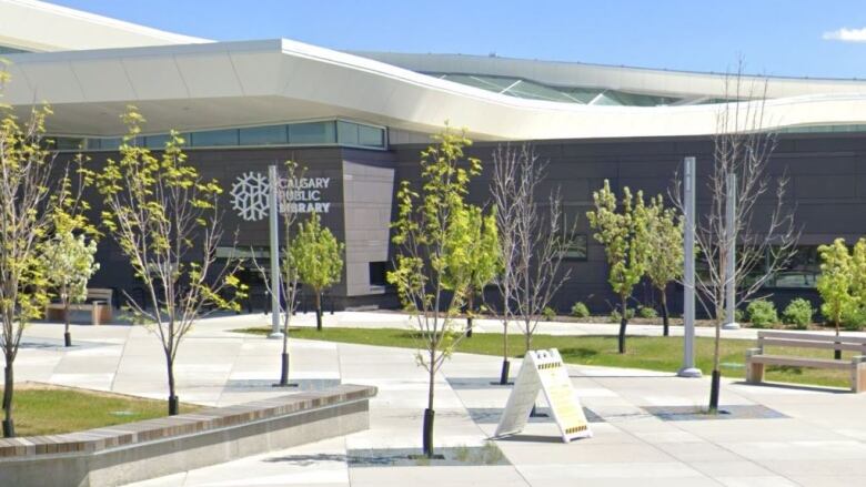 The Calgary Public Library logo is seen on the side of a modern complex that also houses the YMCA.