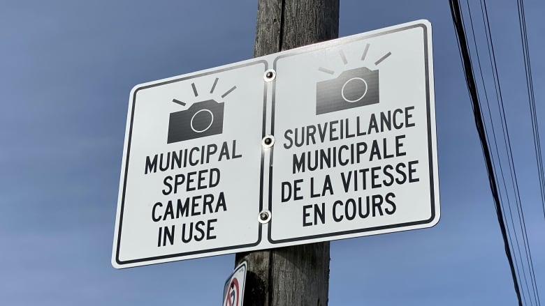 A sign says 'Municipal speed camera in use' and, in French, 'Surveillance municipale de la vitesse en cours.'