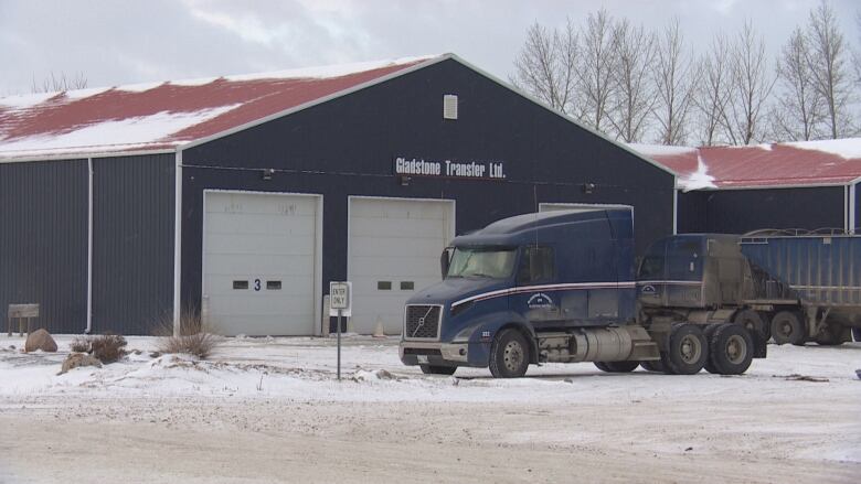 A blue building with the words Gladstone Transfer Ltd on it. In front of the building is a dark blue truck that says Gladstone Transfer.