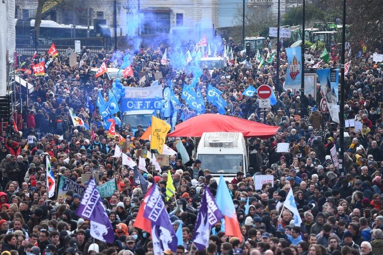 A mass of people, flags and a few vehicles are shown in an apparent demonstration.