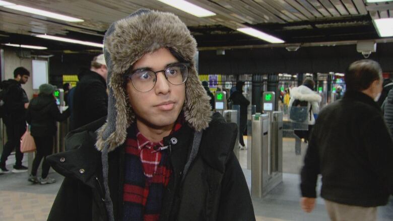 Puranauth appears, wearing glasses and a furry winter heat, with the northbound platform of Dundas subway station in the background.