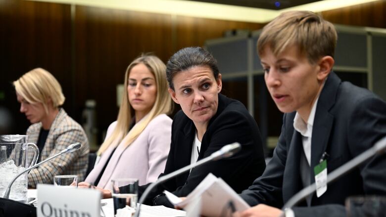 Canadian National Soccer Team players Sophie Schmidt, left Janine Beckie, Christine Sinclair, and Quinn, right, prepare to appear a House committee.