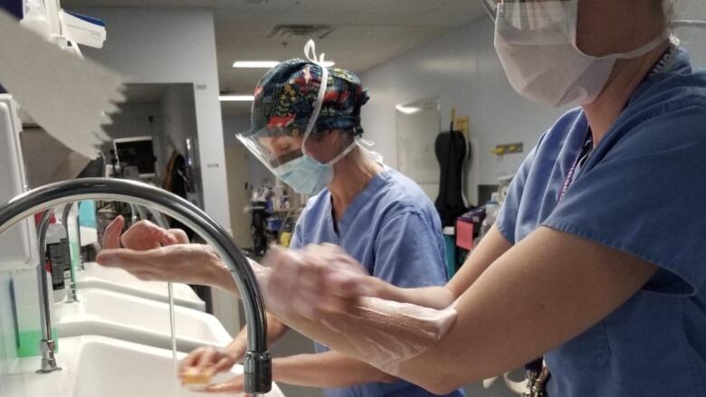 two people scrubbing for surgery 