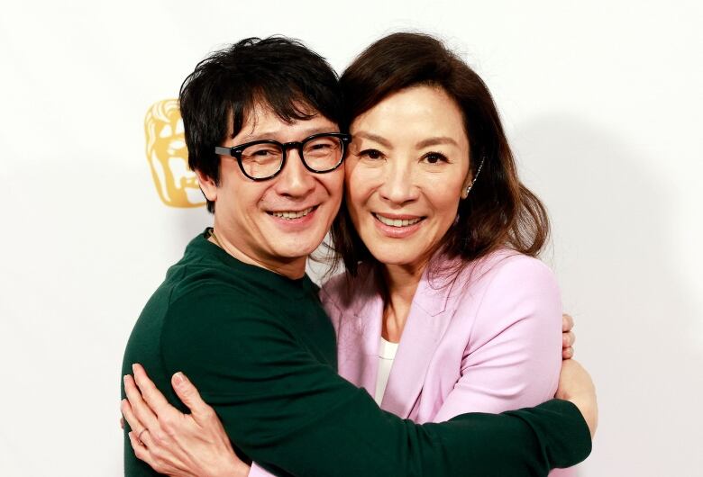 A man and a woman of Asian descent hug each other.