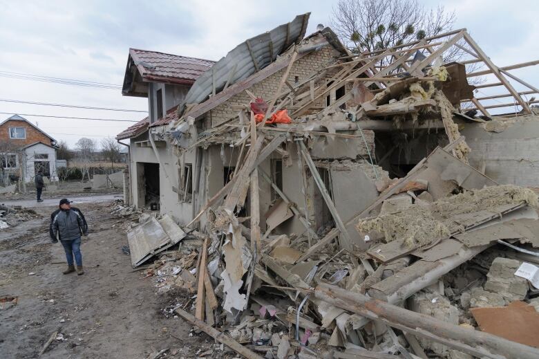 A villager in Lviv's Zolochevsky district looks at damage done by an overnight rocket attack.