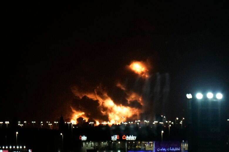 The night sky is shown lit up by a large fire.