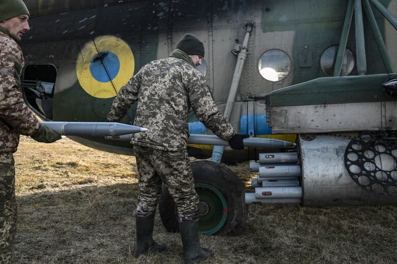 Ukrainian soldiers load rockets on a Mil Mi-8 helicopter in eastern Ukraine on March 10, 2023.