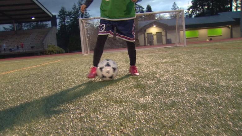 A kid plays soccer.