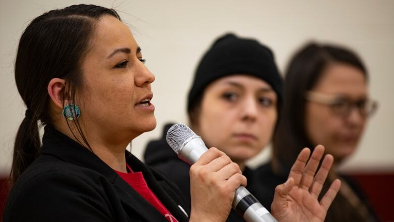 A woman speaks into a microphone.