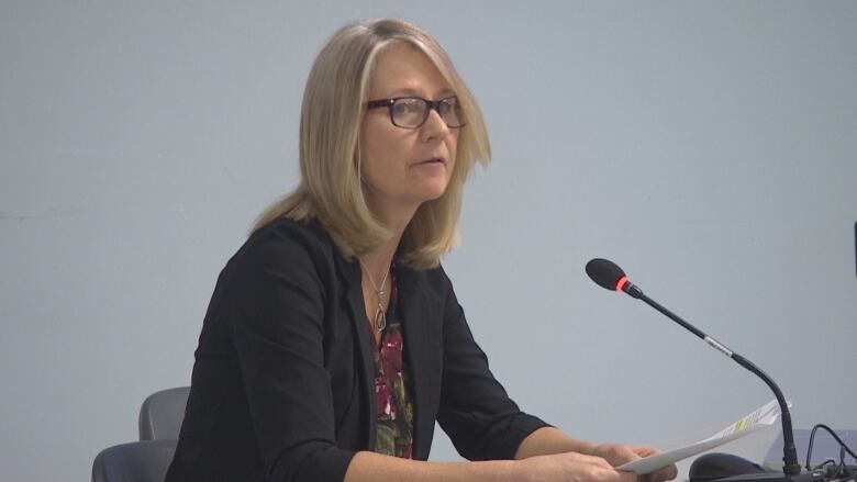 A woman speaks into a microphone.