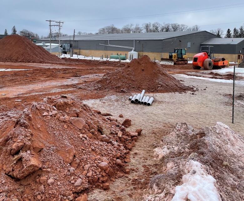 Earth dug up, with old Simmons sports centre in background.