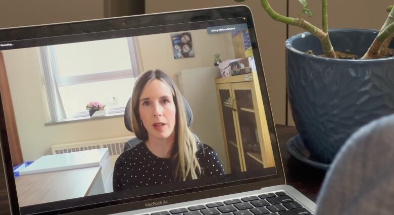 A woman is making a video call on a laptop.