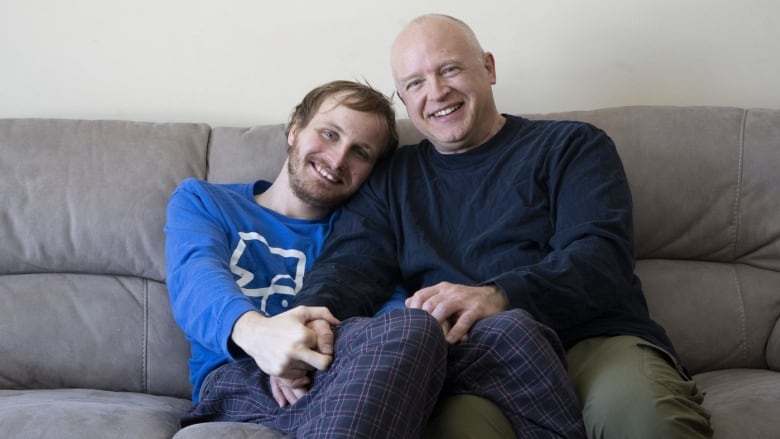 A man and his son pose for a photo.