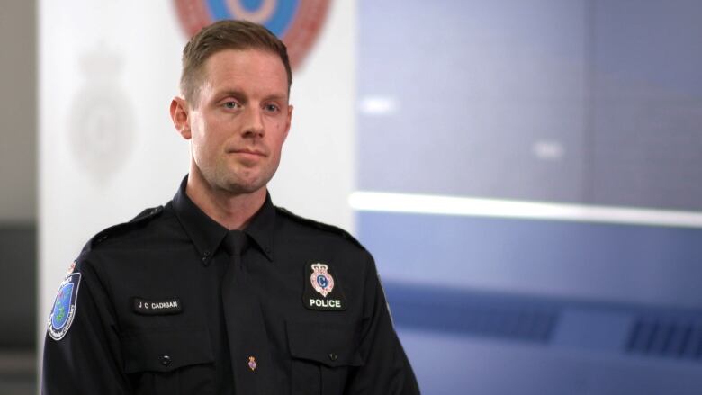 A white, male police officer in uniform with short brown hair.