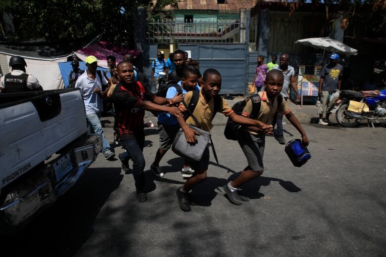 Children run towards their parents at the end of their school day as police carry out an operation against gangs in the Bel-Air area of Port-au-Prince, Haiti on March 3, 2023.