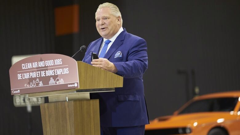 Man smiling at a lectern.