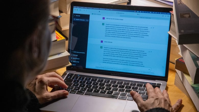 A shrouded face looks at a computer screen showing on screen messages.