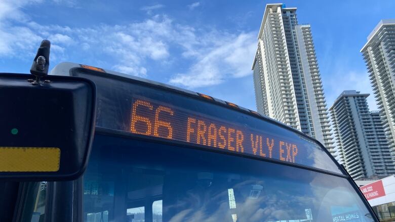 The sign of the 66 Fraser Valley Express bus is lit up at a bus stop.