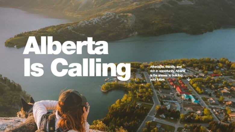 The homepage of the Alberta is Calling website is seen. It shows a woman with a dog on a cliff while she take a picture of a small town below.