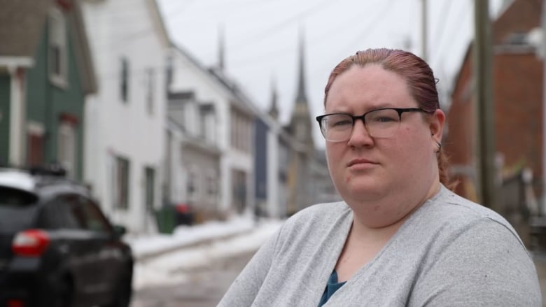 Corinne McQuillan faces the camera wearing a grey shirt with a blurred background.