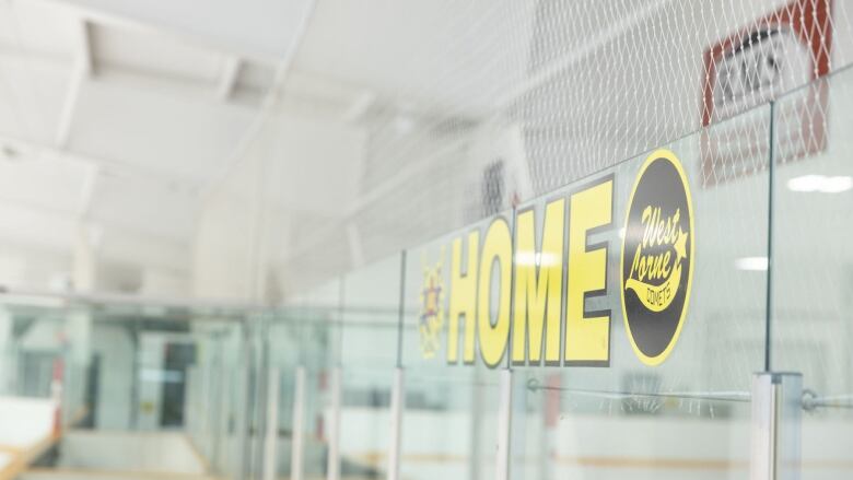 An empty rink with empty stands and a sign that says HOME. 