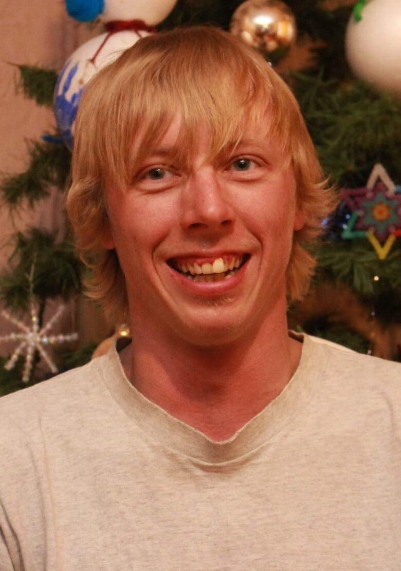 adult photo of Randall Fehr smiling by a Christmas tree