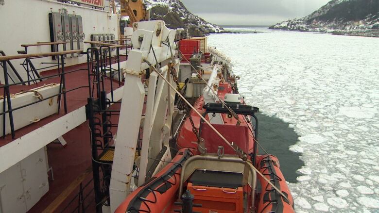 A large boat makes a path through ice-covered water.