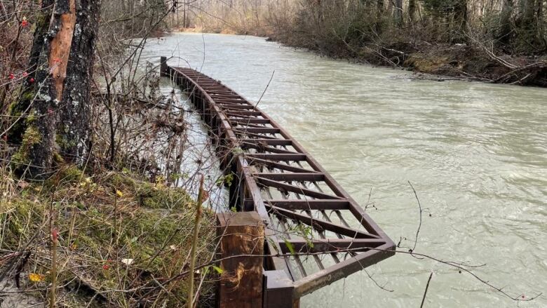 A damaged bridge is seen lying in a river.