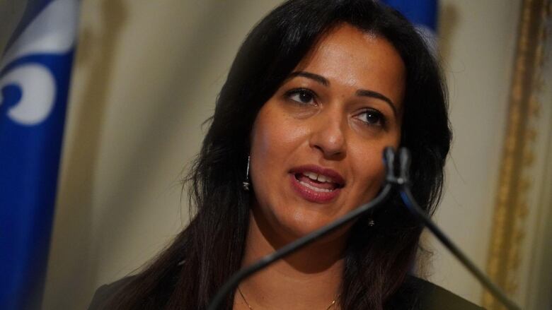 A woman speaks in front of a microphone.