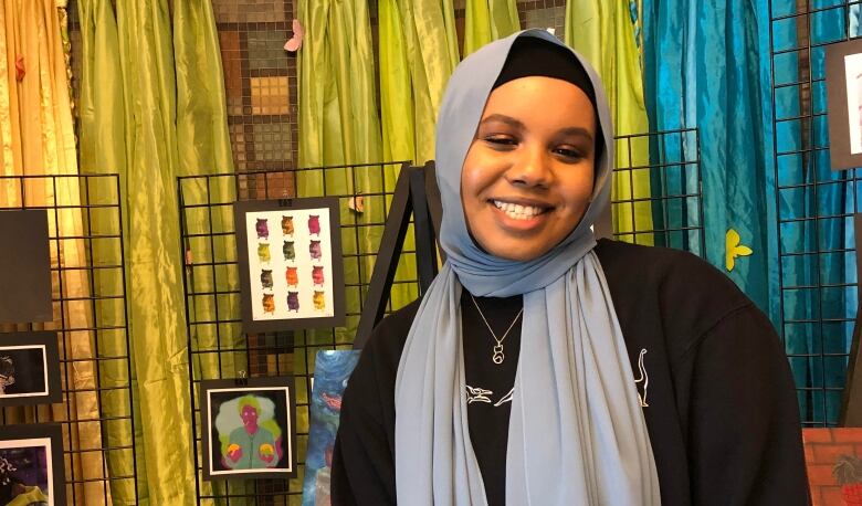 smiling woman in light blue hijab and black sweater