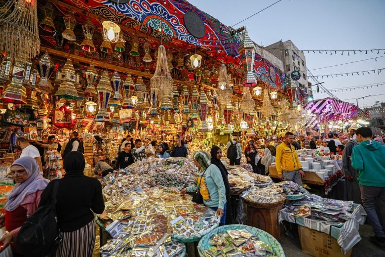 People browse at a market stall selling traditional lanterns and foodstuff ahead of Ramadan.