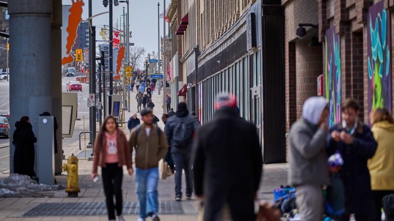 People walk on a busy street.