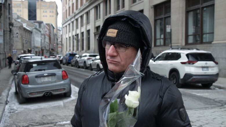 a man holds a white rose