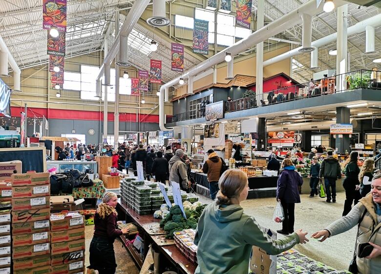 Locals buy produce and fresh goods at the Kitchener Farmer's Market 