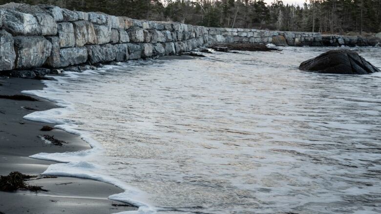 Waves splash up against the bottom of a seawall recently built at Little Crescent Beach on Nova Scotia's south shore.