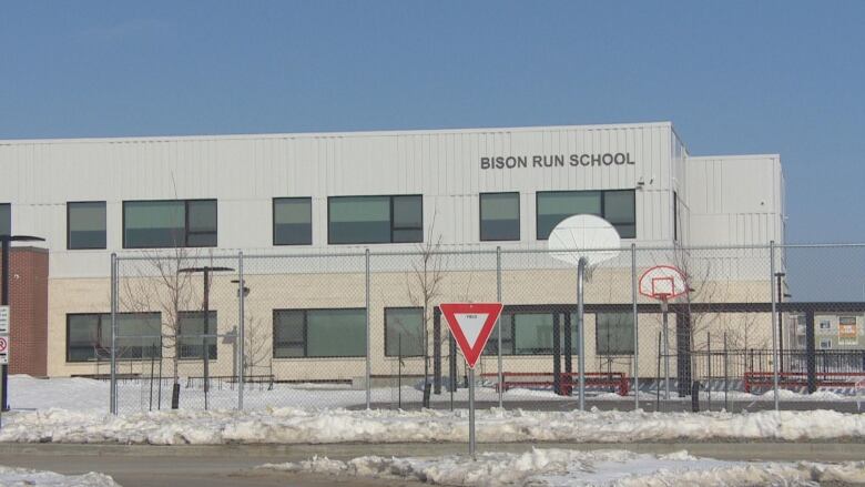 A school with a basketball court outside.