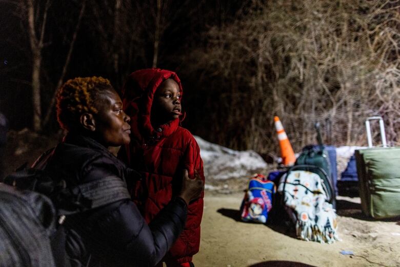 A woman and her child look longingly towards something. 