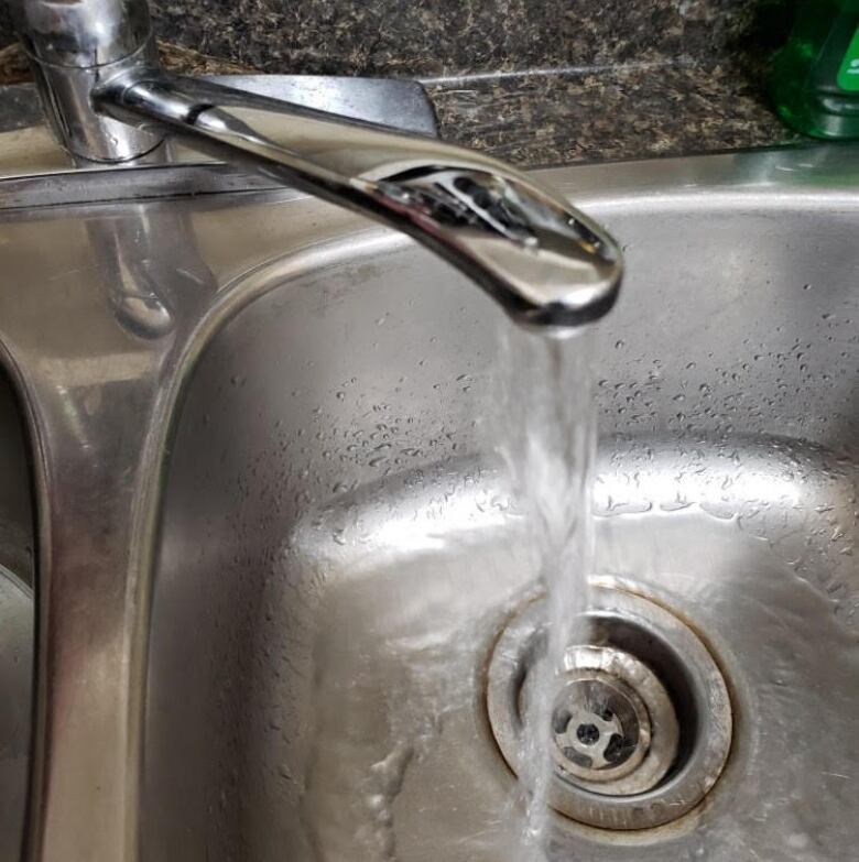 Water comes out of a tap.