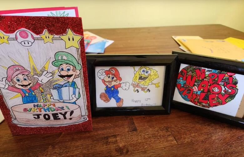 Three framed colourful cards. Two include mario kart images and one says Annapolis Valley. 