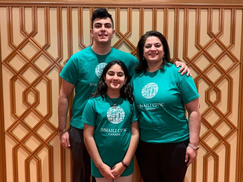 son, daughter and mother all pictured in green volunteer shirts.