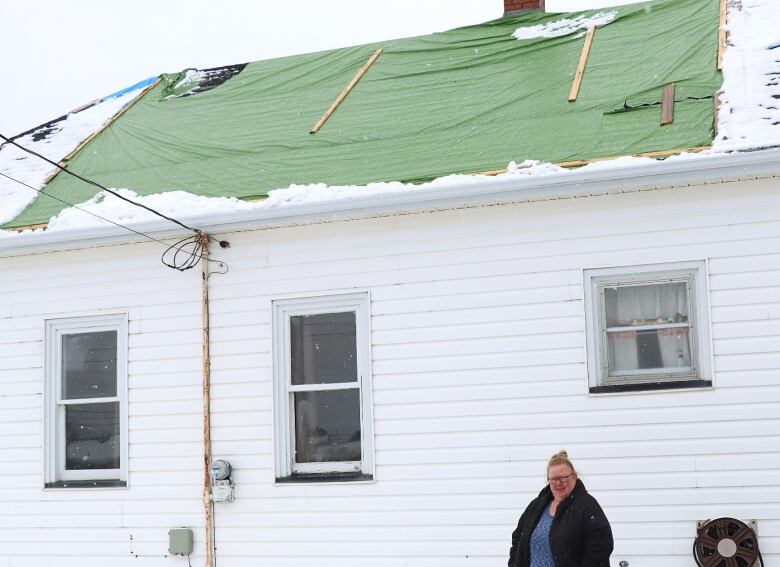 Natasha Murphy, a Glace Bay homeowner, stands in front of her home that was damaged in September 2022 by post-tropical storm Fiona. 