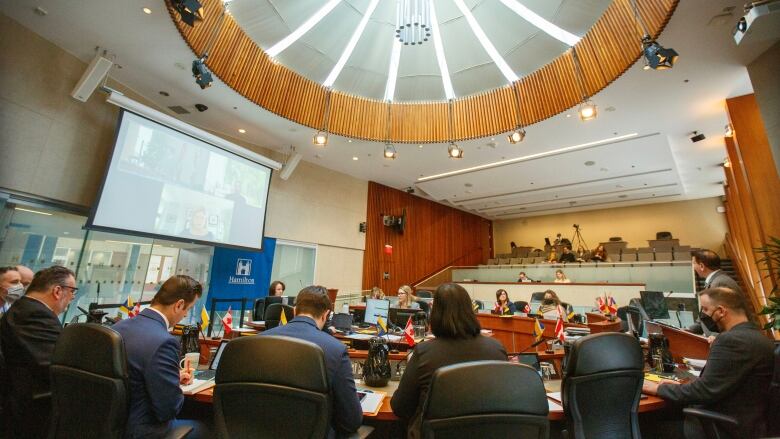 People sit around a table in council chambers