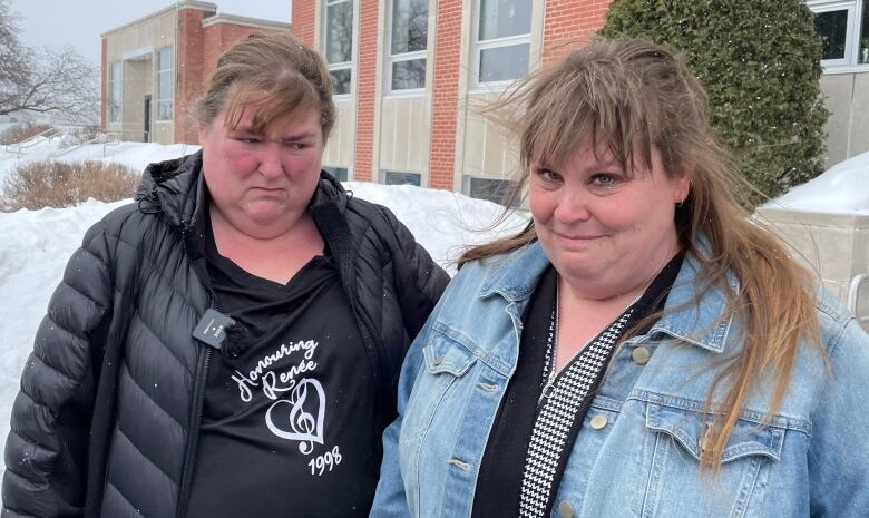 Two women stand outside in the snow outside of the Sudbury courthouse