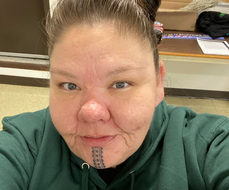 A selfie of a Cree woman showing her full face and a cultural tattoo design on her chin.